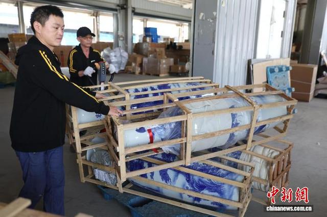 图为一家物流企业工作人员使用拖车搬运大型瓷瓶。中新社记者 刘占昆 摄