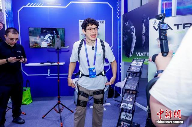 11月6日,外国观众在“互联网之光”博览会上体验外骨骼穿戴设备。(主办方供图)