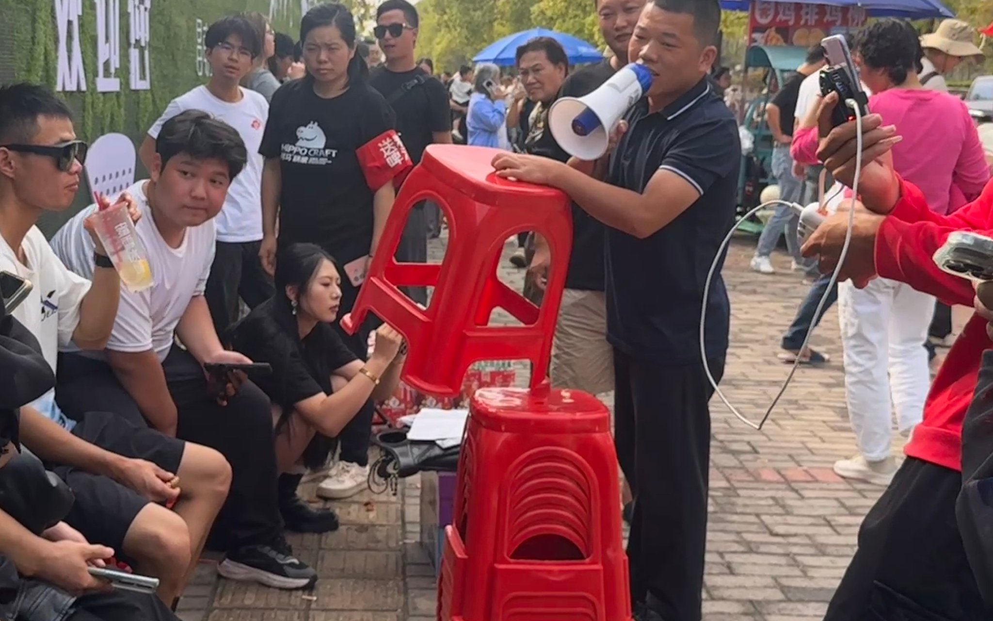 10月15日，凳子哥在雞排攤前發凳子，維持現場秩序。 新京報記者 熊麗欣 攝