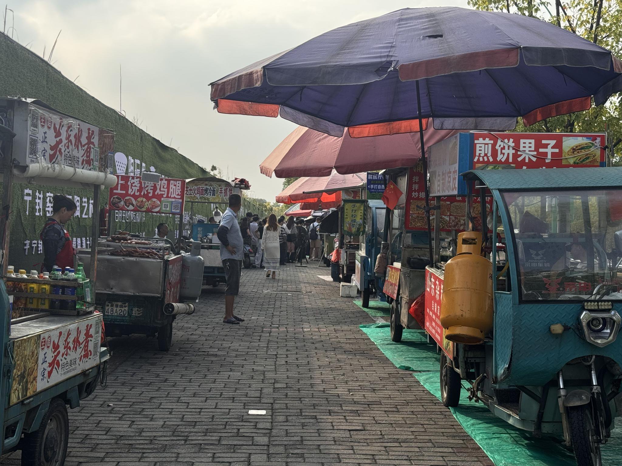 10月16日，雞排哥出攤後，顧客被吸引過去，其他攤位變得冷清。 新京報記者 熊麗欣 攝