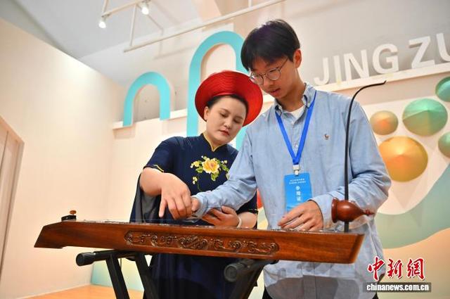 赵霞教媒体代表弹奏独弦琴。俞靖 摄