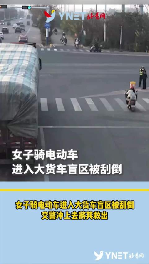 女子骑电动车进入大货车盲区被刮倒 交警冲上去将其救出