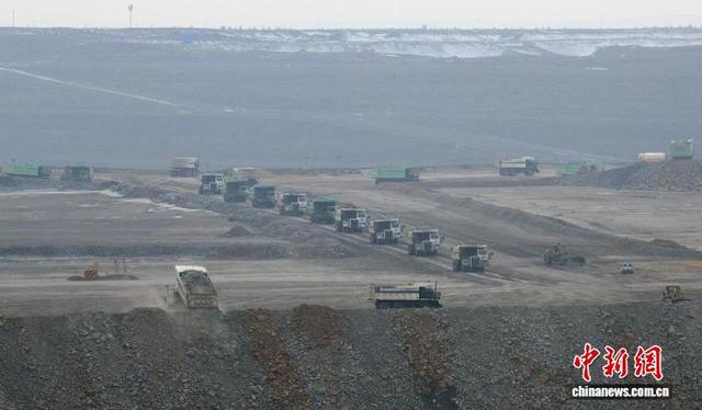 图为在准东宜化五彩湾一号露天煤矿有序作业的各种大型车辆。中新网记者 孙亭文 摄