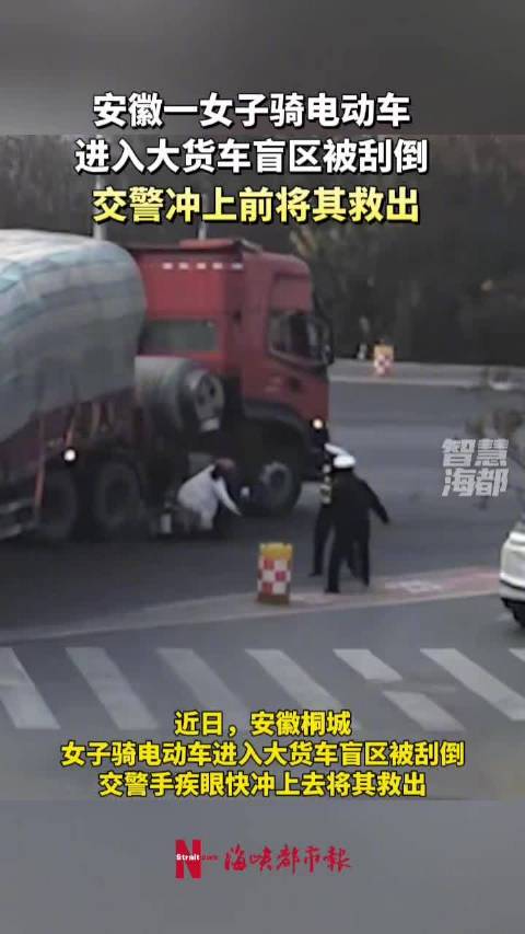 安徽一女子骑电动车进入大货车盲区被刮倒，交警冲上前将其救出