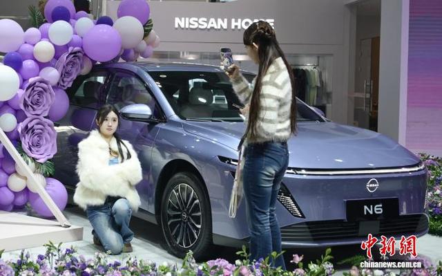 年轻人在车企布置的打卡区拍照。中新网记者 唐小晴 摄