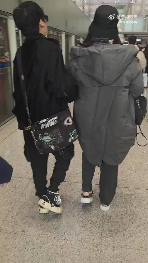 大张伟与妻子机场亲密同行