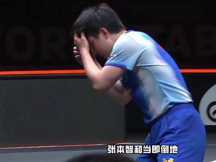 张本智和激动跪地，以手势向樊振东致意，随后抱起教练庆祝胜利