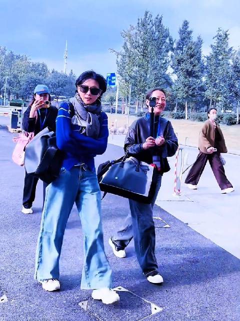 万茜蓝色毛衣牛仔裤现身片场，干练穿搭步履匆匆