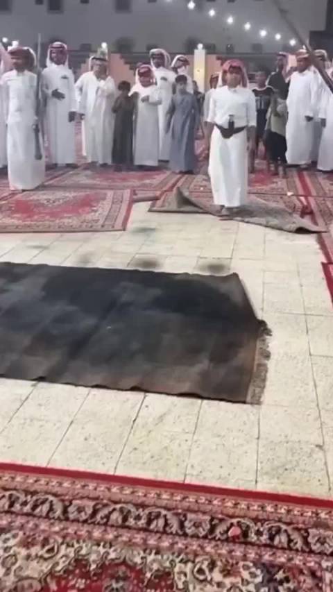 沙特传统战争舞蹈Taasheer表演者跳跃朝地面开枪