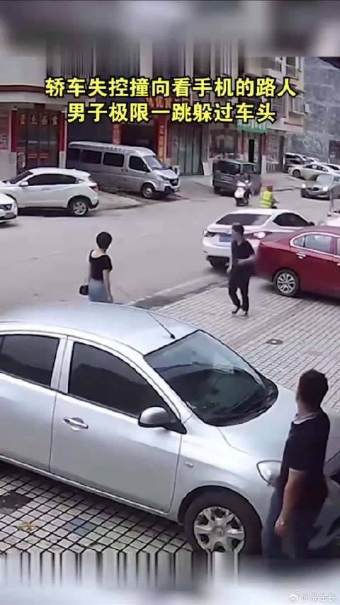 轿车失控撞向看手机的路人，男子极限一跳躲过车头
