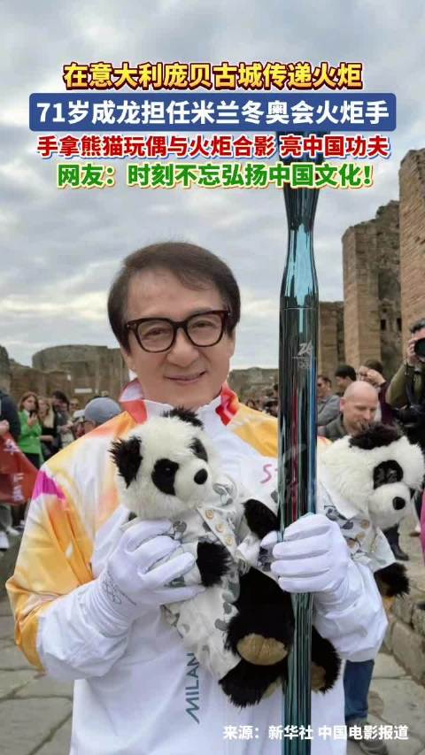 成龙手持熊猫玩偶与火炬合影