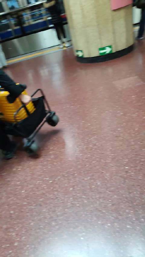 男子携多件行李赶车，抱露营车行李箱上下地铁