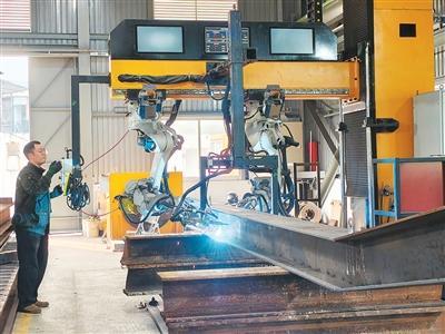 图为香港和利绿色动力有限公司员工梁志豪使用智能焊接系统焊接钢材。新华社记者 刘英伦摄