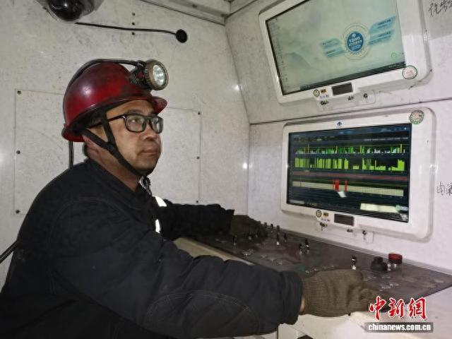 赵华成在集控中心的操作台旁，轻点按钮，百米外的采煤机即可启动。张圆圆 摄