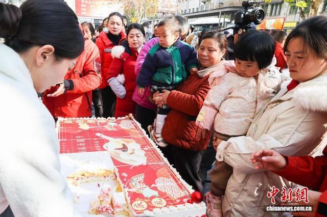 图为现场工作人员为市民分发庆典蛋糕。中新社记者 张畅 摄