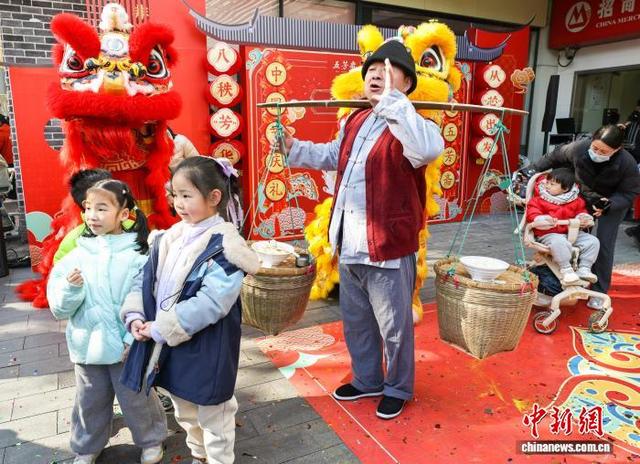 图为现场小朋友们与“挑担郎”互动合影。中新社记者 张畅 摄