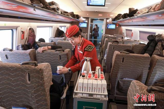 京哈高铁列车长在车厢内为旅客提供服务。记者 贾天勇 摄