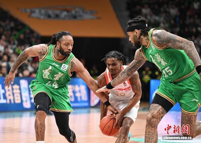 图为深圳马可波罗队球员约翰逊(中)在比赛中带球进攻受阻。中新社记者 于海洋 摄