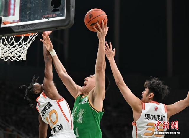 图为辽宁本钢队球员付豪(中)在比赛中上篮。中新社记者 于海洋 摄
