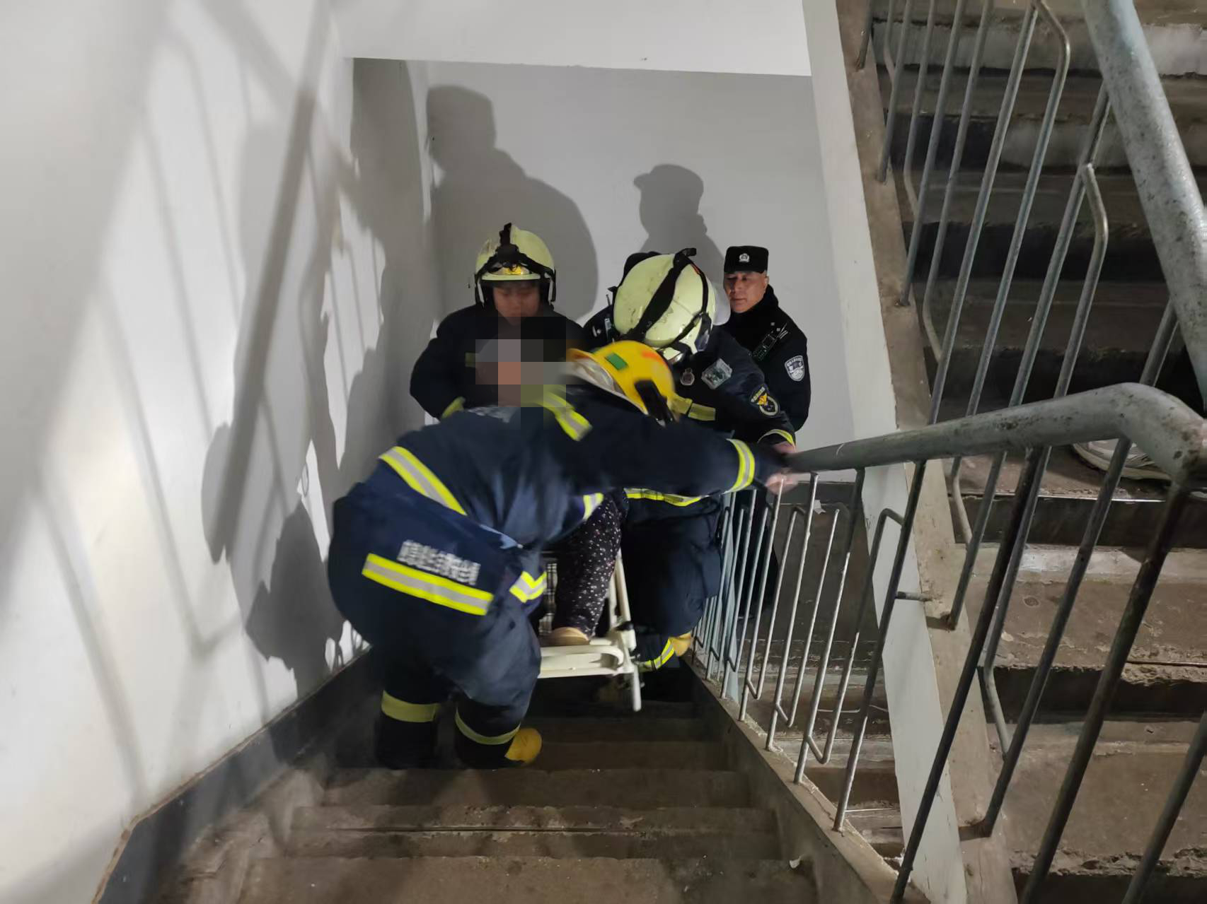 三人小心翼翼地將老人從輪椅上平穩抬起，並給老人做好腰部、腿部的防護支撐。東城消防供圖