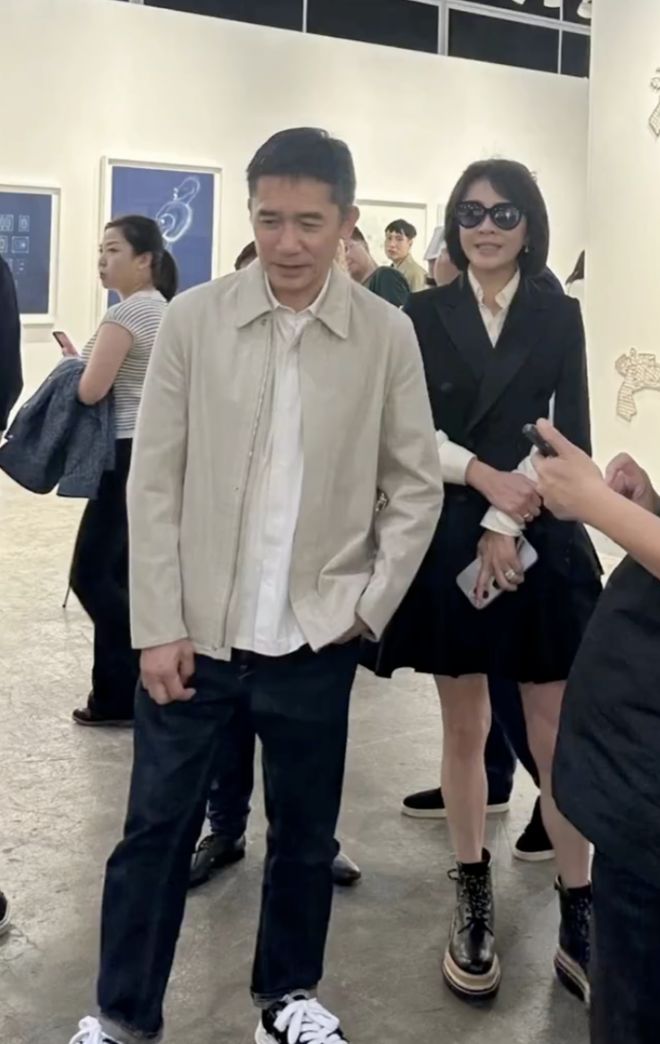 梁朝伟夫妇看展被偶遇，刘嘉玲穿百褶裙秀美腿，梁朝伟抿嘴好害羞