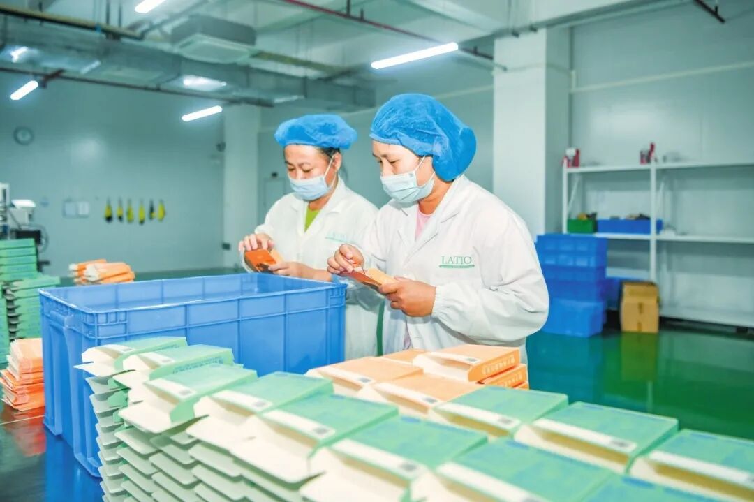 在加绿巧食品制造业（海南）有限责任公司生产车间内，工作人员正在生产线上忙碌。