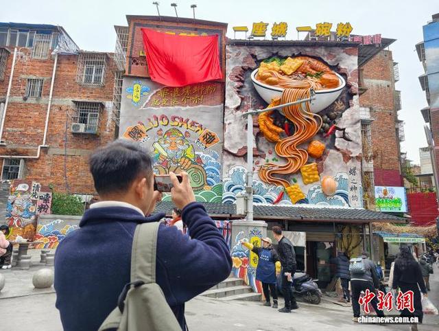 1月27日，广西柳州市青云菜市一大型螺蛳粉雕塑吸引游客打卡。林馨 摄