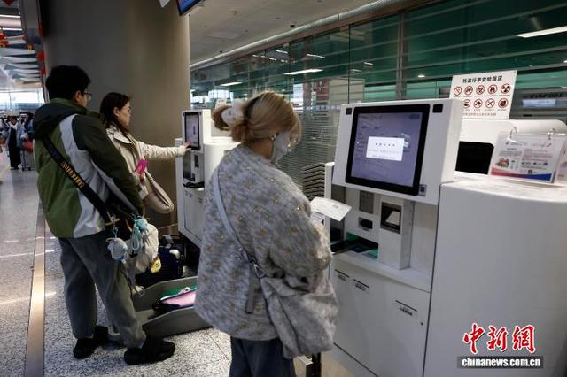 2月2日，旅客在上海虹桥国际机场T2航站楼内的东航自助托运柜台办理行李托运手续。中新社记者 殷立勤 摄