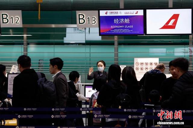 2月2日，在上海虹桥国际机场T2航站楼内的东航柜台，工作人员引导旅客前来办理登机手续。中新社记者 殷立勤 摄