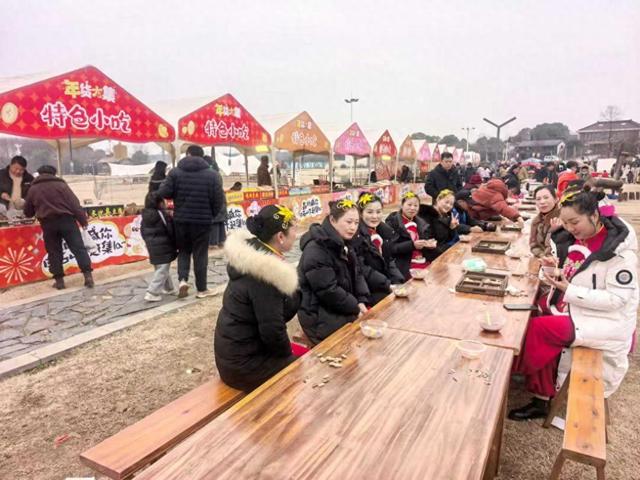 1月31日，溧水区晶桥镇石山下村年货大集现场，特色小吃区的长桌旁坐满了参与民俗表演的演员与游客。张福敏摄