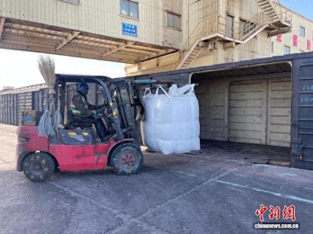 图为工作人员将肥料装载至货运车厢。 段亚慧 摄