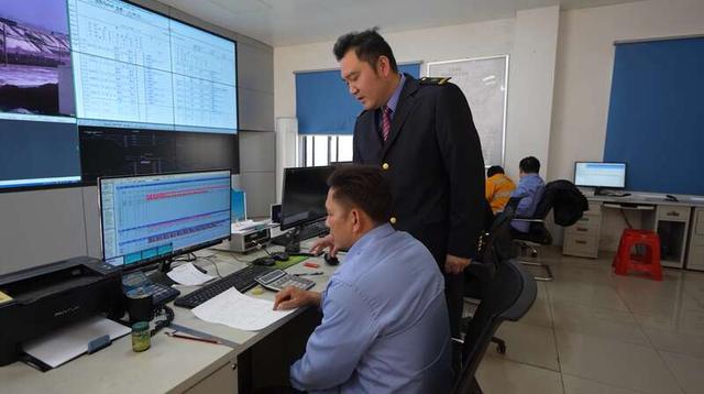 国铁南宁局沿海铁路公司钦州港东站副站长赵坚（前排右一）在站调室梳理班列发运情况。中青报·中青网记者 谢洋/摄