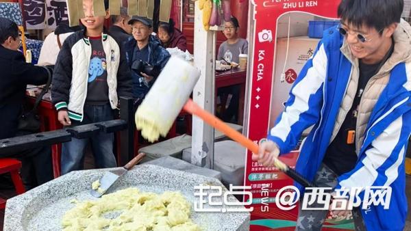 游客在永兴坊体验非遗打糕