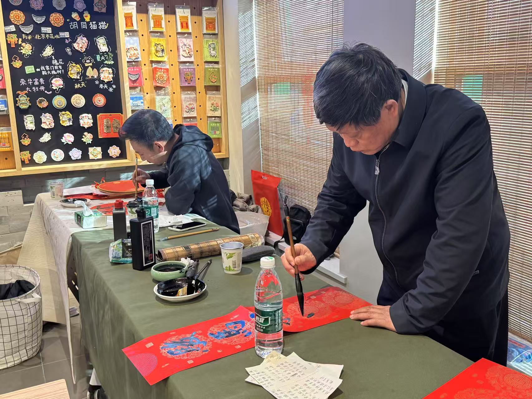 施童（左）、段京良（右）等嘉賓現場寫福字、寫春聯。新京報記者徐彥琳 攝