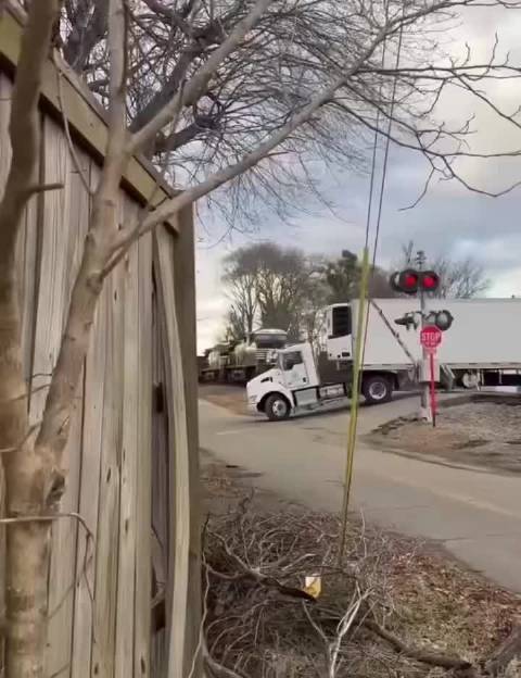 美国半挂卡车卡在铁轨被火车撞翻