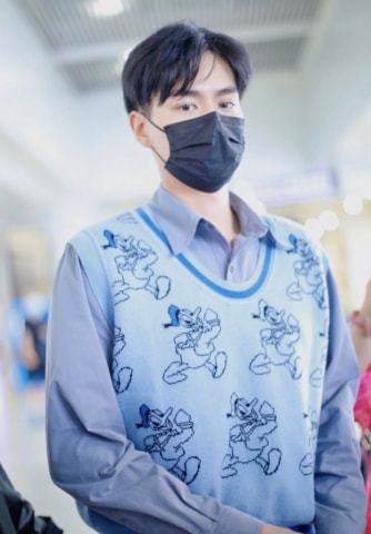 胡一天机场私服照，唐老鸭印花马甲随性帅气，演绎标准男友穿搭