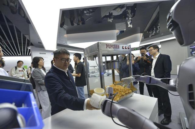 2025年10月29日，在广东深圳越疆科技有限公司，机器人为记者装爆米花。新华社记者 刘力航 摄