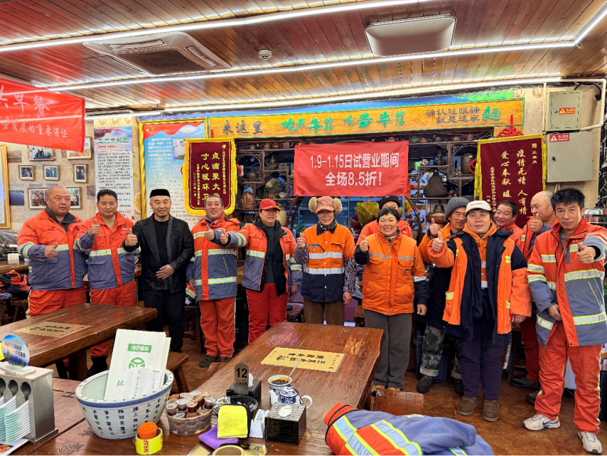 王黑麥（左三）為環衛工人送拉麵。首都文明辦供圖
