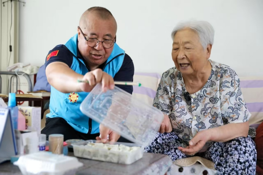 陳時田（左）為老人送餃子。首都文明辦供圖