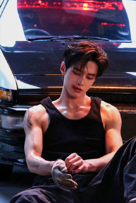 何与的白背心造型具体展现了哪些身材特点，为何被称为‘少年感与肌肉的反差’？