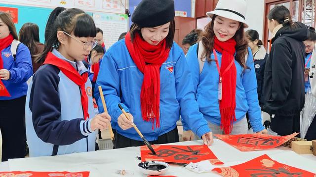 2月9日，柳州市鱼峰山小学，越南青年代表和小学生共同书写福字，感受中国年味。中青报·中青网记者 谢洋/摄