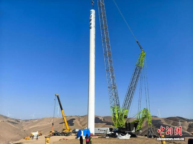 图为庆阳绿电聚合新能源项目风机塔筒吊装场景。 甘肃电投集团供图