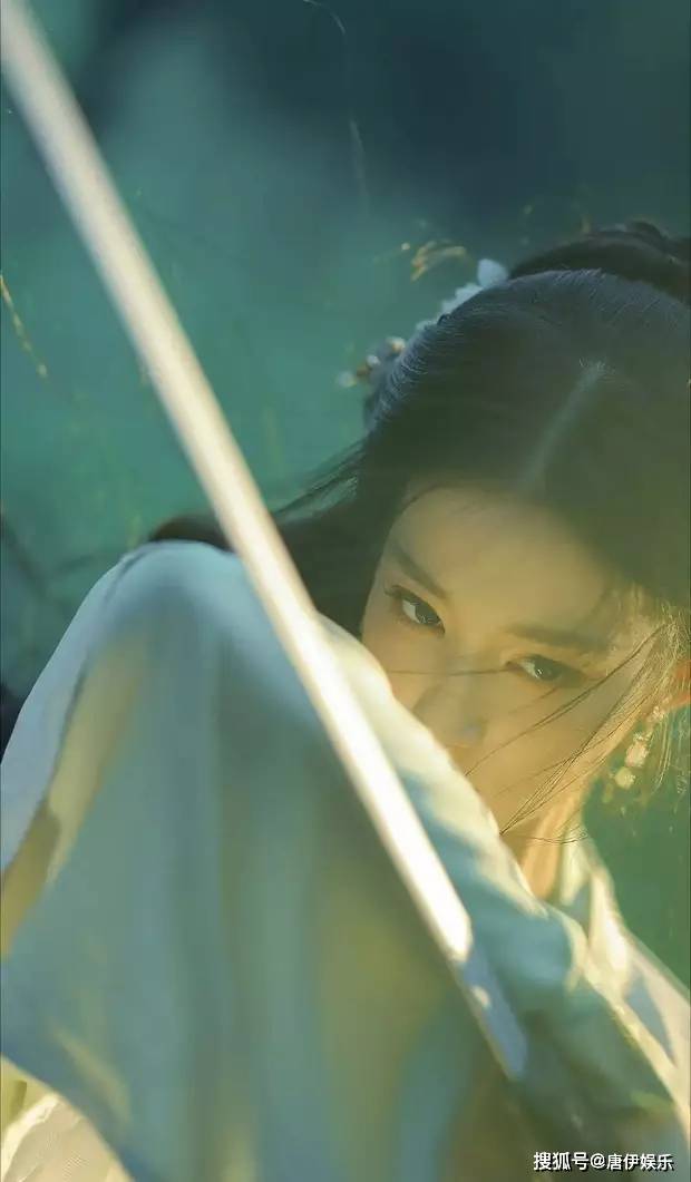 王楚然白衣执剑，眼神坚定，清冷气质直击心灵，逆光回眸，氛围感爆棚