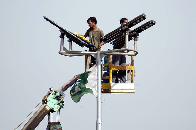 2025年12月14日，巴基斯坦卡拉奇，技术人员正在对新安装的太阳能路灯进行维护工作。视觉中国 资料图