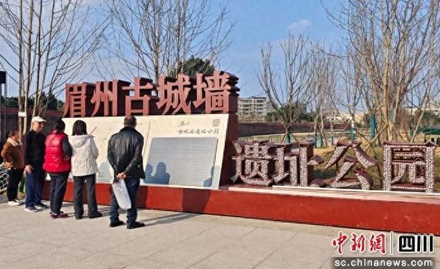 眉州古城墙遗址公园介绍吸引市民驻足。东坡融媒供图
