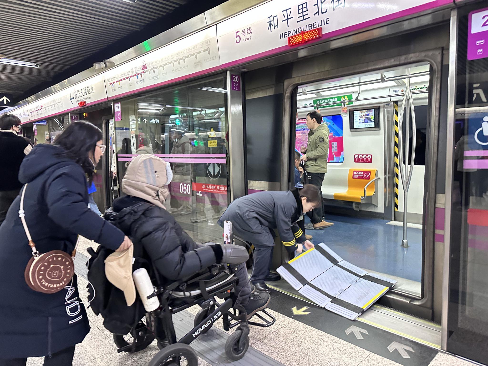 站區技術助理桑治雪幫助一位輪椅乘客上車。新京報記者 裴劍飛 攝