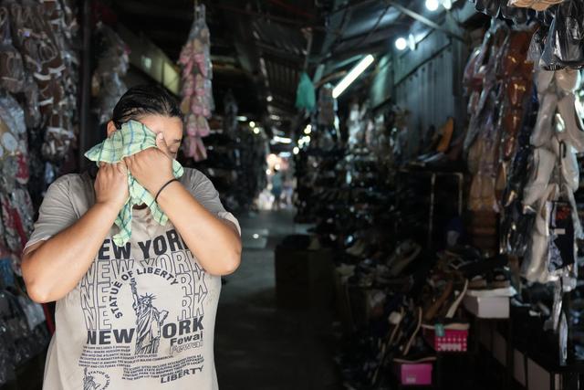 当地时间2026年2月19日，巴拉圭亚松森，一名市场销售人员在炎热的夏日擦拭脸上的汗水。视觉中国 图