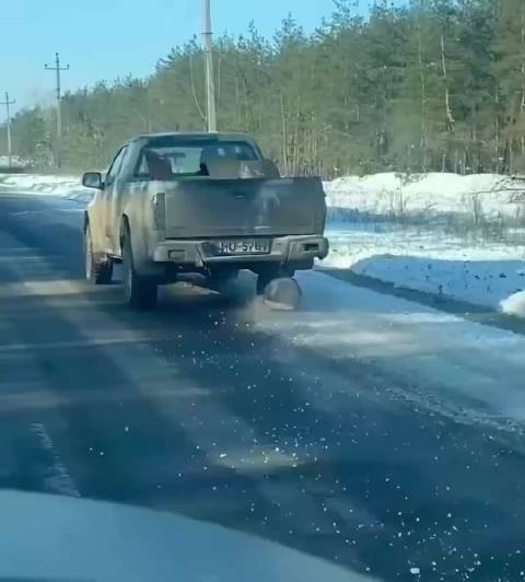 乌克兰军用皮卡从前线返回途中，用圆木垫在车轴下替代被毁轮胎