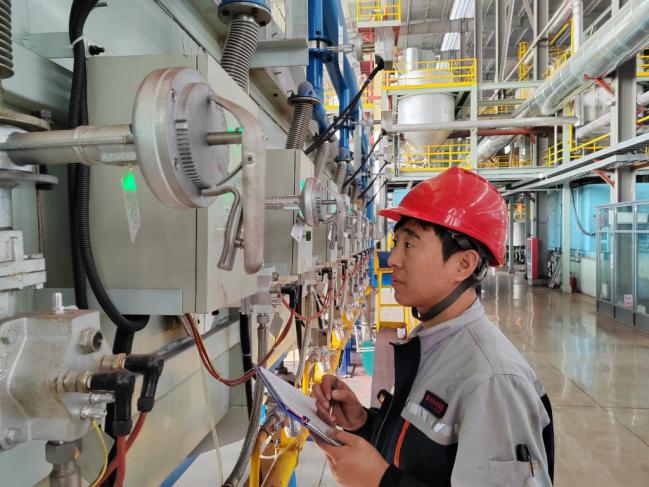 山东春光磁电科技有限公司工作人员正在查看“锰锌铁氧体软磁元件用颗粒料”生产设备运行情况。（资料照片）