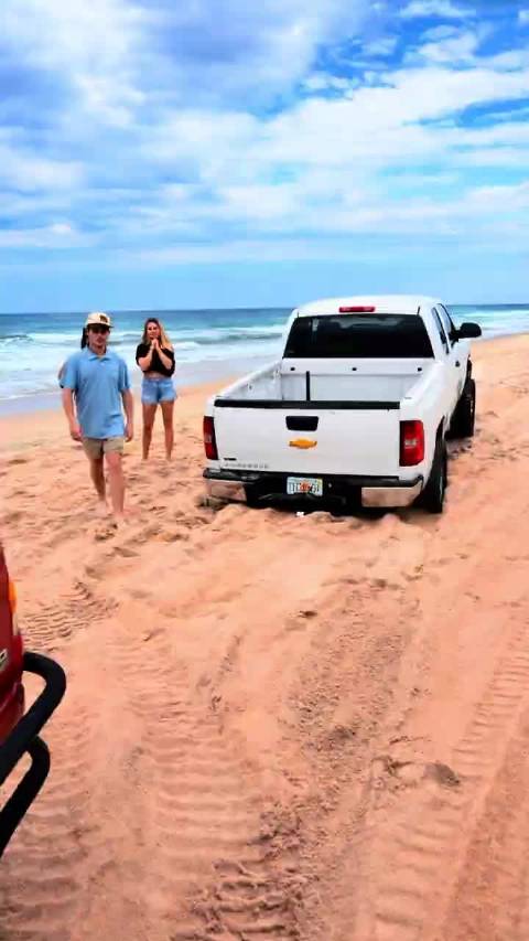 男子驾皮卡带两女进沙滩陷坑